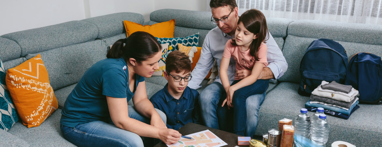 A family gathers in their living room to assemble their home emergency kit.