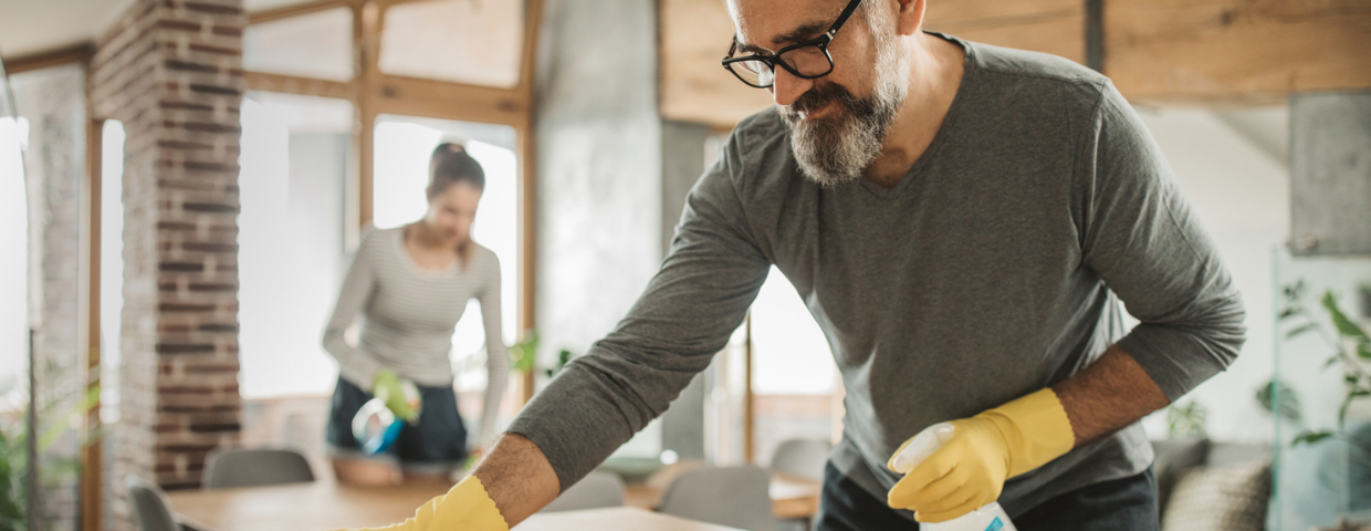 A man and a woman clean their kitchen.