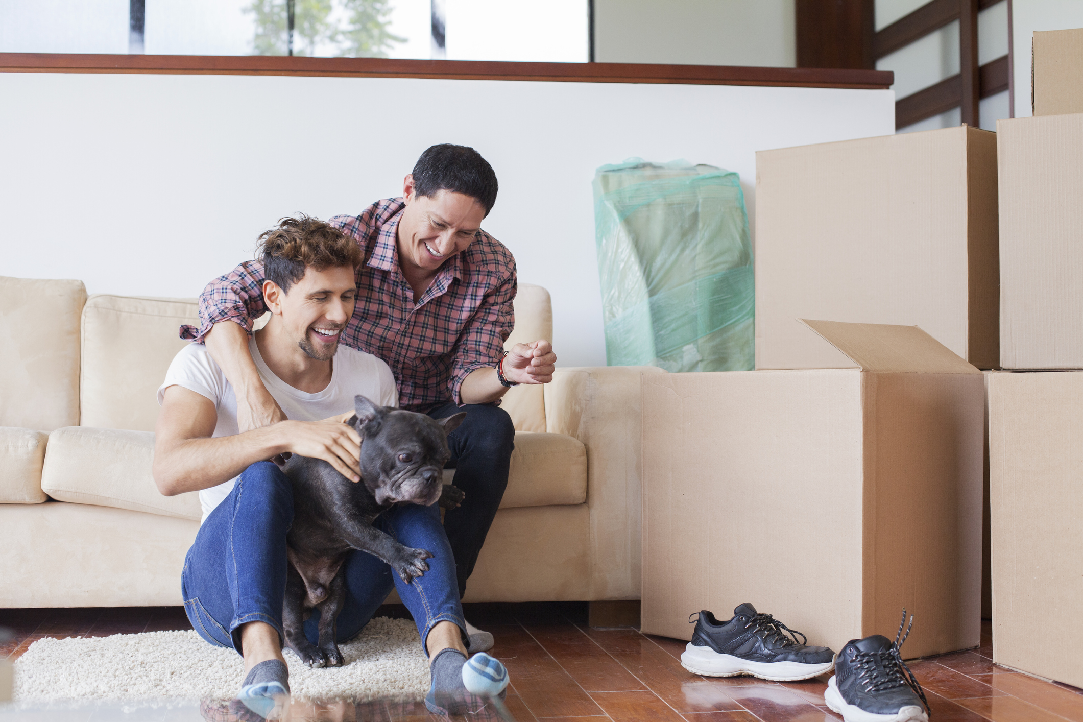 Two men and their dog move into a new home. 