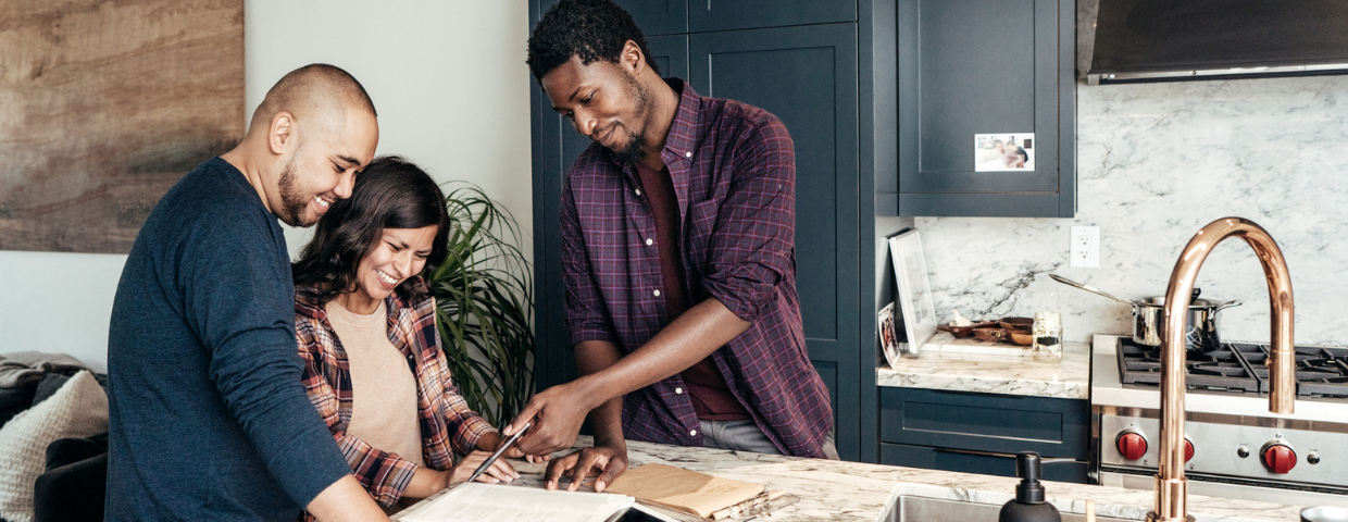 A real estate agent goes through paperwork with a man and a woman.