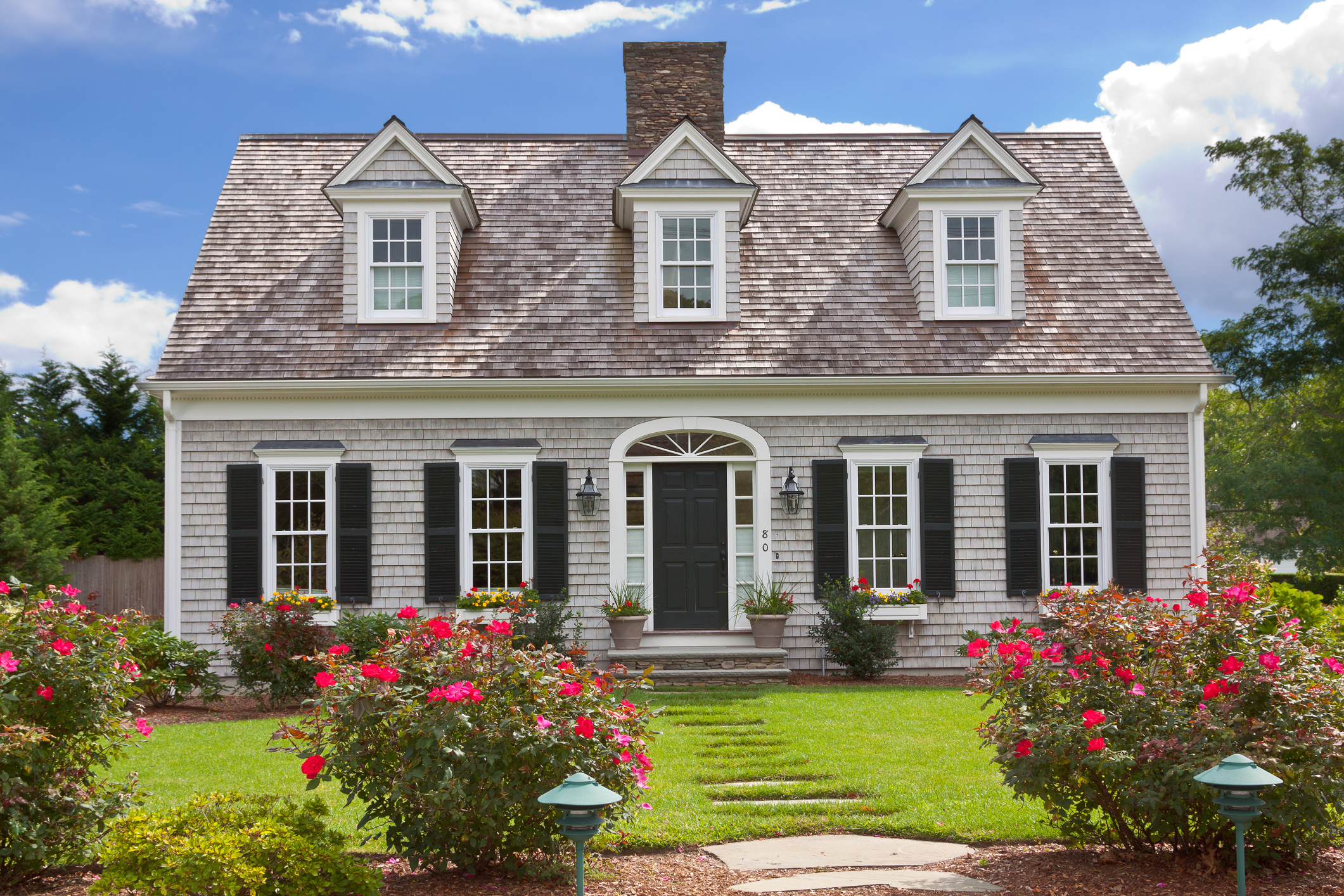 A close-up of the exterior of a cape cod home.