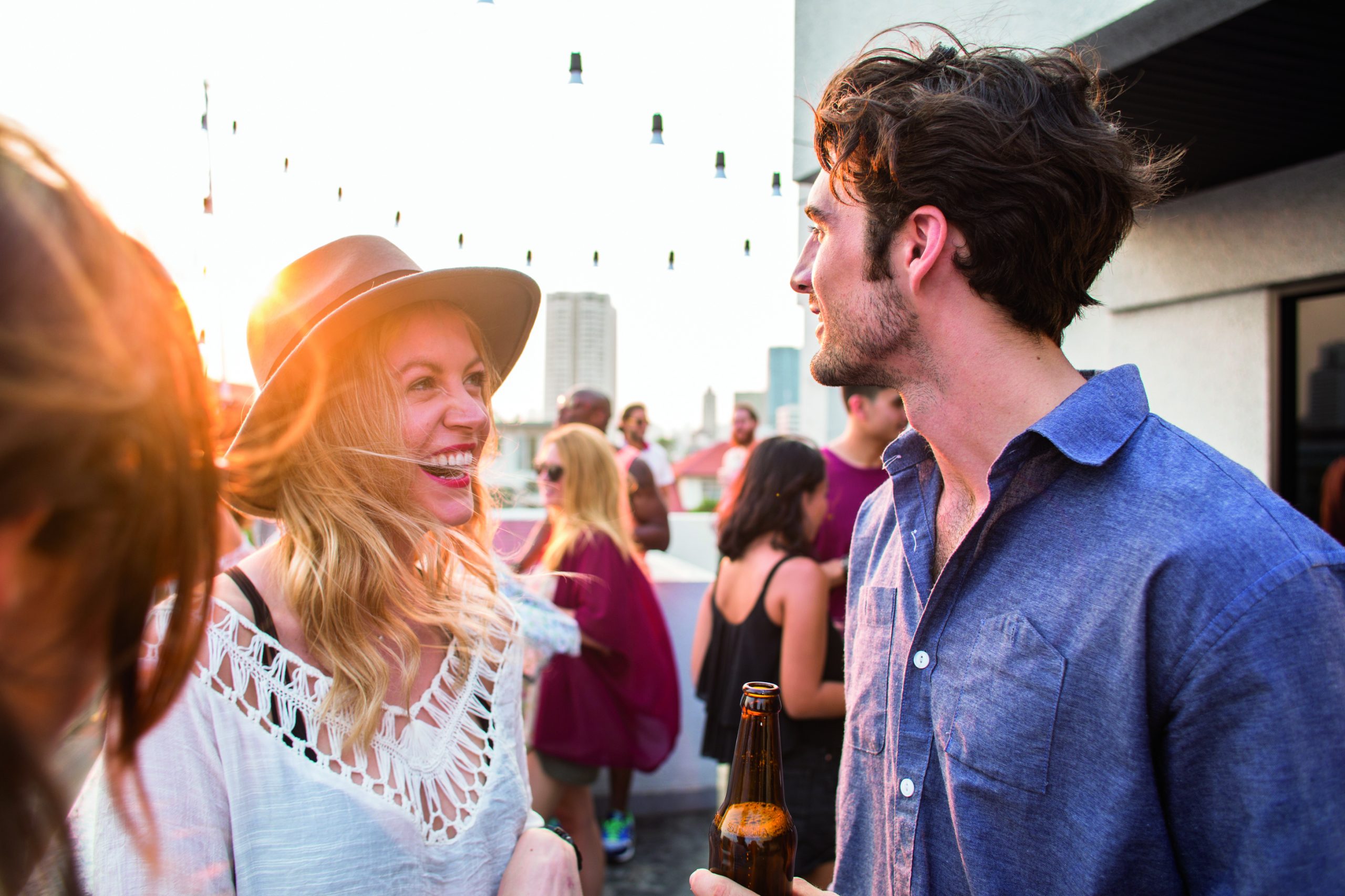 A man and a woman attend an outdoor party during sunset.