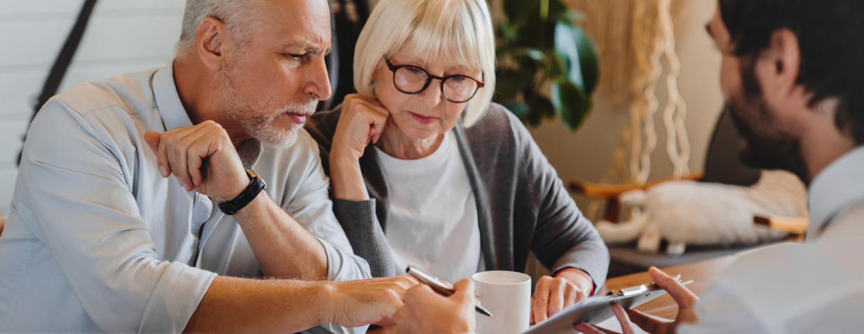 An elderly man and woman discuss selling their home with their Windermere agent.