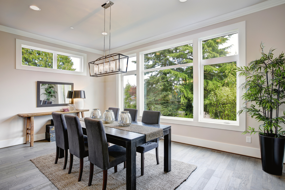 A dining room with hardwood floors, black chairs, and a black table.