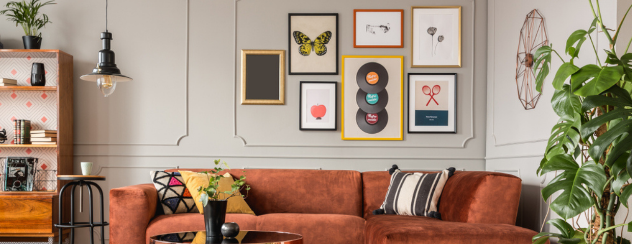 A living room with a gallery wall containing several framed posters, paintings, and other works of art.