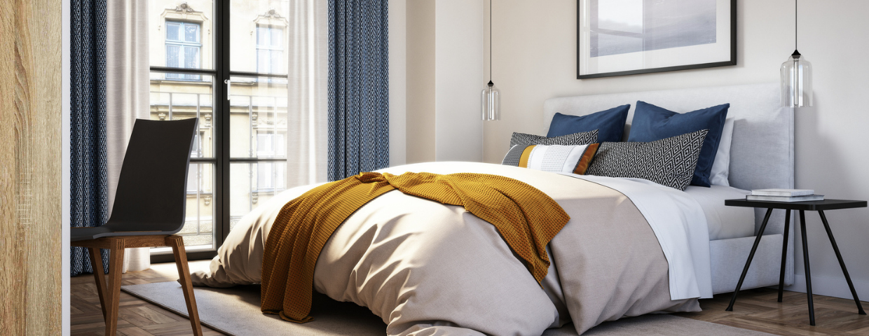 A plush mattress decorated with blankets and pillows in a modern bedroom.