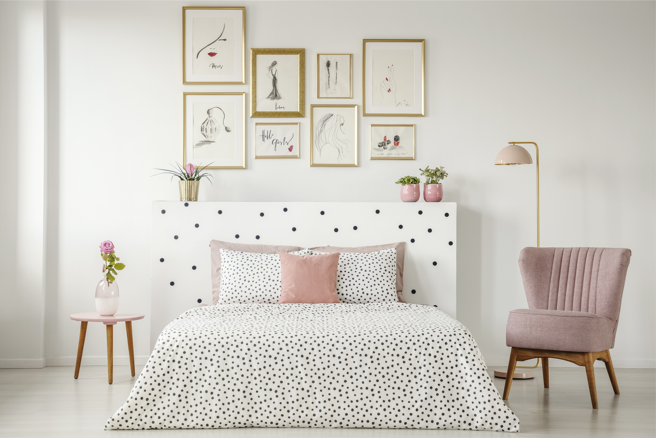 A bedroom with a gallery wall above the headboard of the bed.