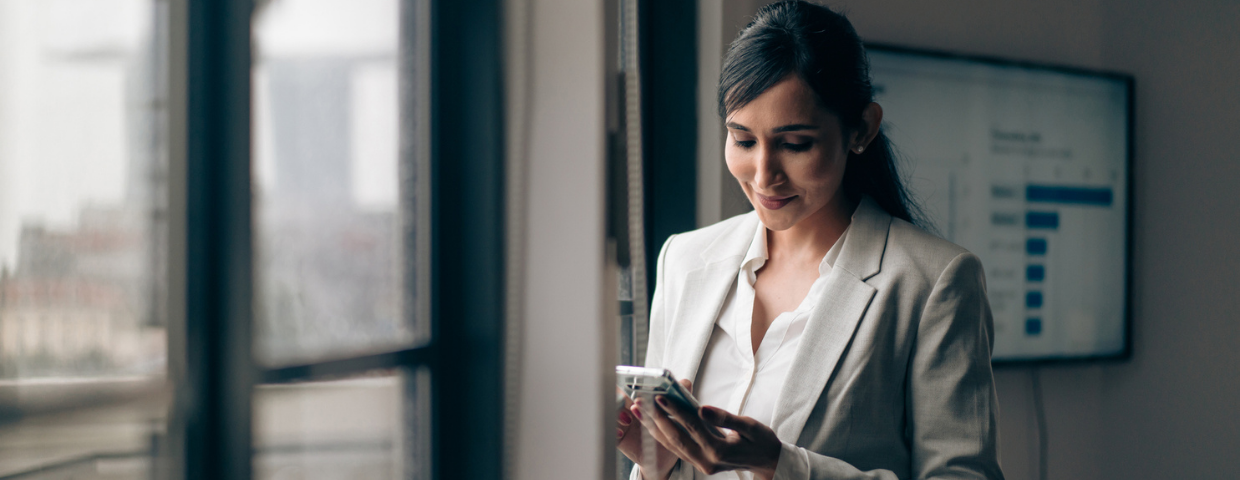 A real estate agent looks at her phone in her office.