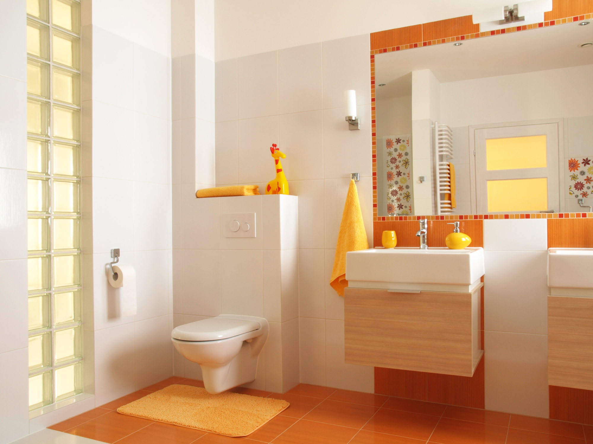 A colorful bathroom with orange tile flooring and orange and yellow accents.