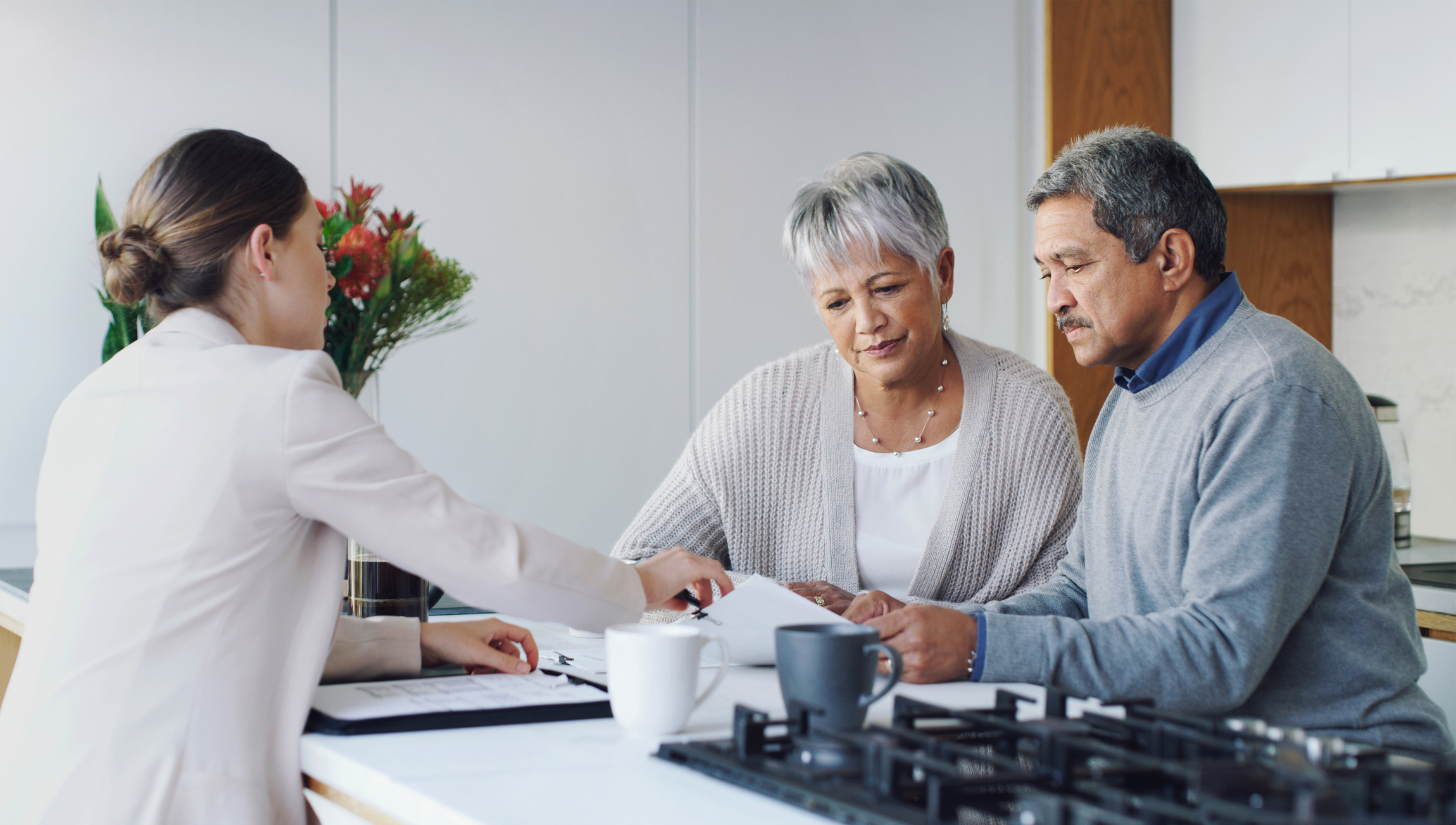 A man and woman signing their escrow paperwork at a table.