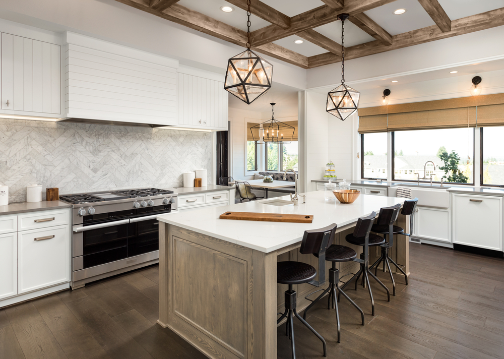 A farmhouse style kitchen with white surfaces, exposed beams, and wood accents.