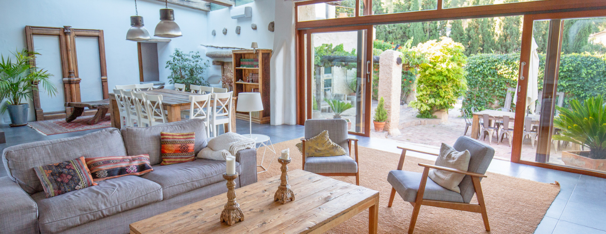 The living room of a farmhouse style home with an open sliding door to the outdoor patio.