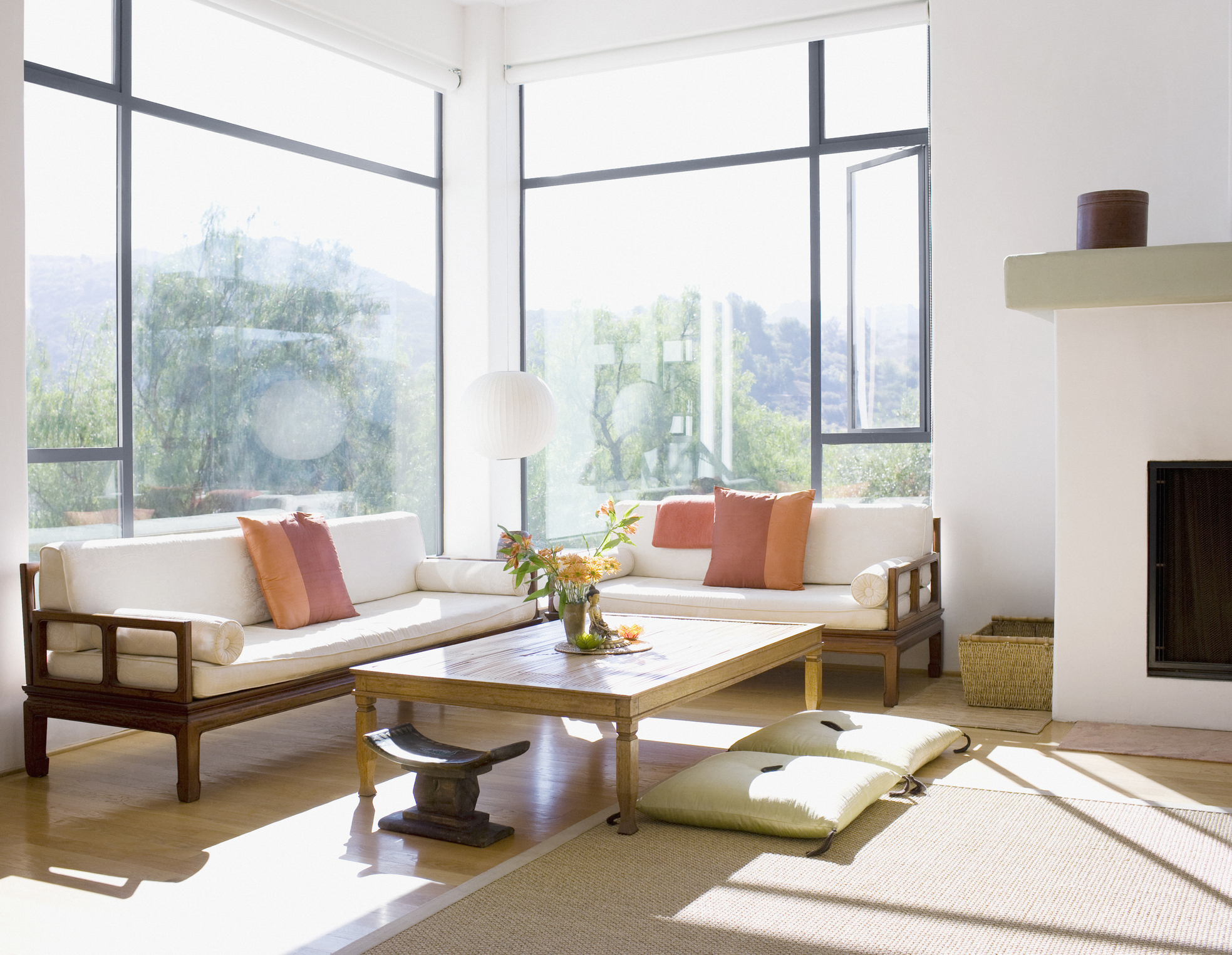A living room with the sun pouring in through the windows.