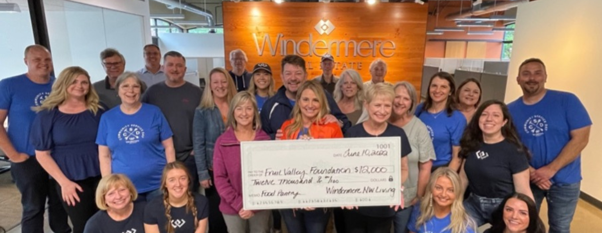 A group of Windermere agents and staff hold up a check for $12,000.