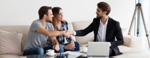 A young man and woman shake hands with their real estate agent.