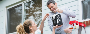 Man and woman homeowner couple repainting the exterior of their house