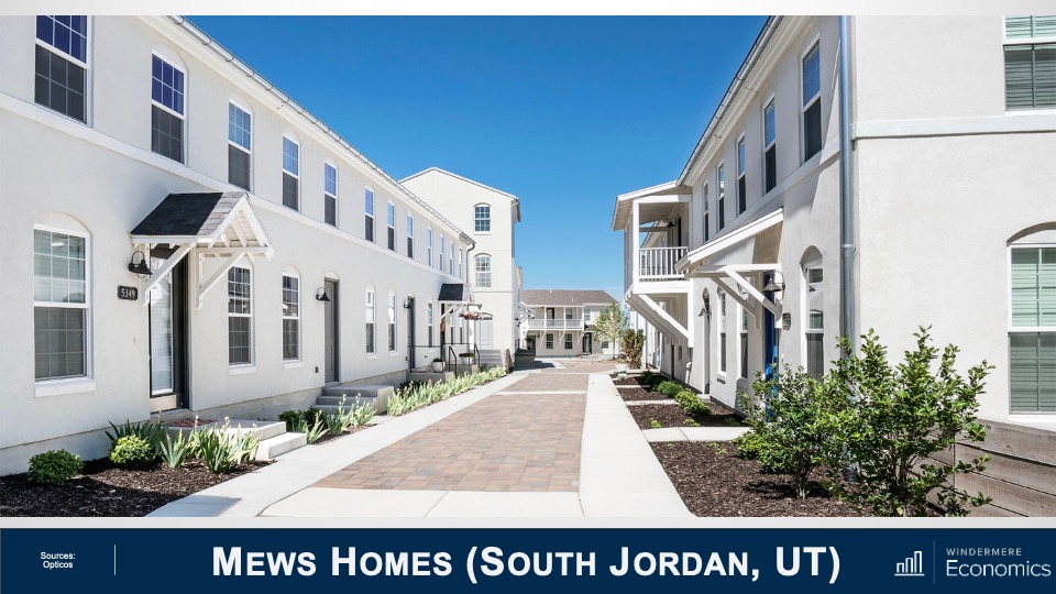 A community of Mews Homes in South Jordan, Utah painted white with arched windows and small eaves hanging above the doorsteps.