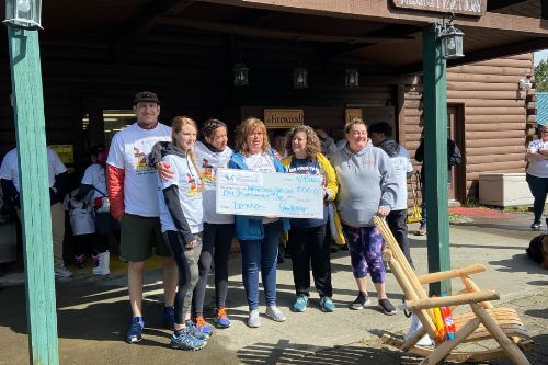 Agents from the Windermere Oregon Coast Offices and reps from the Autism Society of Oregon Clatsop County Chapter hold up a donation check for one thousand dollars