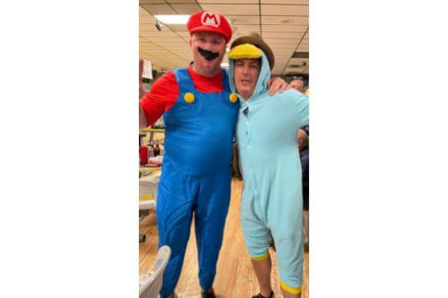 Two adult men dressed as cartoon characters for a bowling fundraiser event
