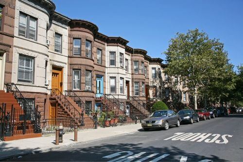 A street-level view of Brownstone row houses in Brooklyn, New York