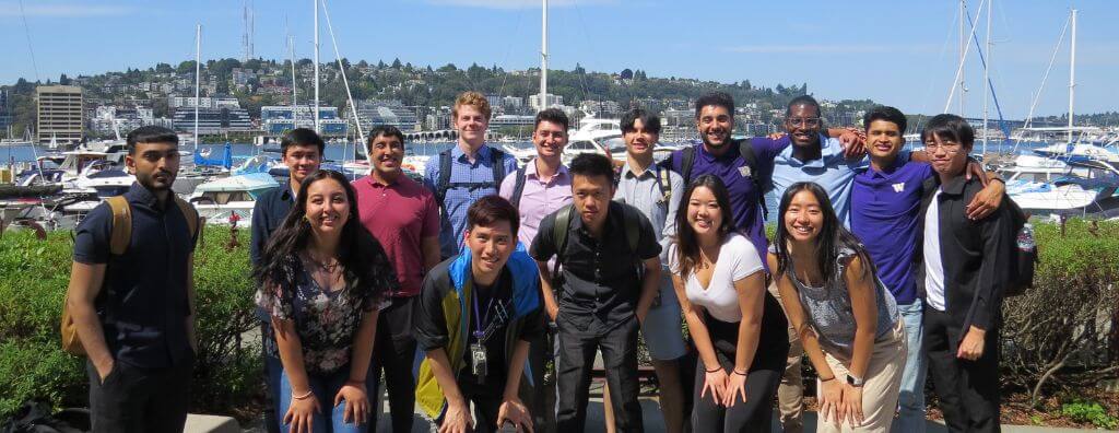 The 2022 class of Windermere-UW College of Built Environment Aspire interns standing together near the Eastlake marina outside Windermere Real Estate headquarters
