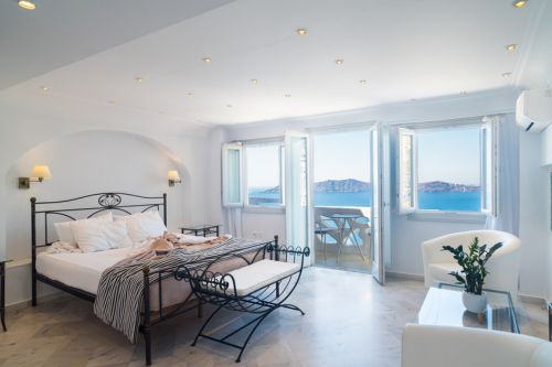 A Mediterranean interior design style bedroom with typical coastal design elements like stucco and natural décor.