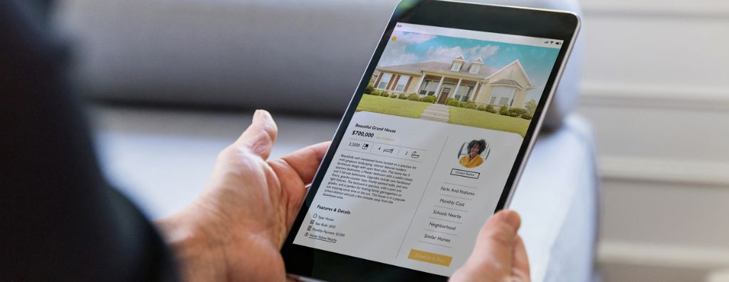 A closeup of a person’s hands holding a tablet searching for homes online. They are looking at a listing for $700,000.