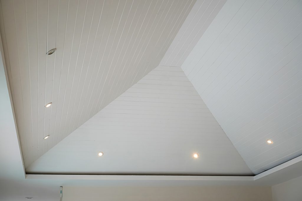 Picture of a high ceiling with modern triangular design that has an airy appearance with decorative lights for decorating a bedroom, living room or luxury hotel room.